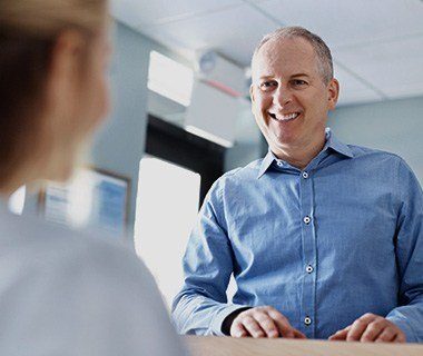 Smiling man checking in at front desk